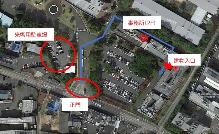 事務所周辺の航空写真。正門から建物入口までの経路と来客用駐車場の位置を示している。