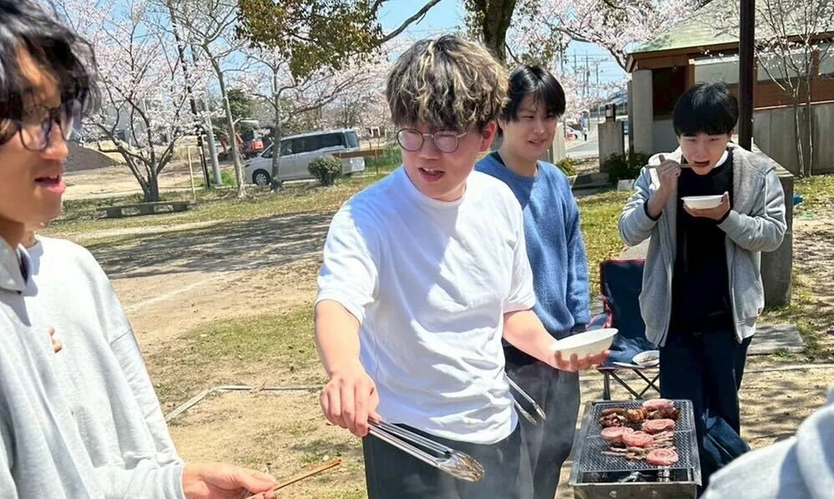 お花見BBQで炭火を囲む職員たち