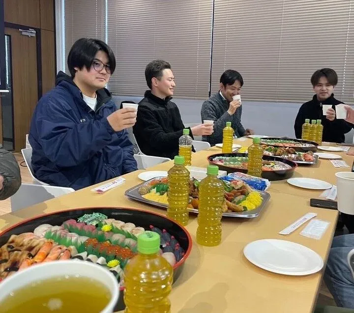 事務所の会議室で食事をしながら話す職員たち