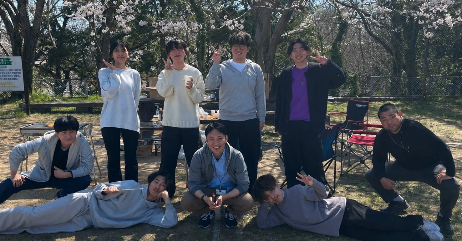 桜の下でドボクリエイトの職員が集まって撮影した集合写真