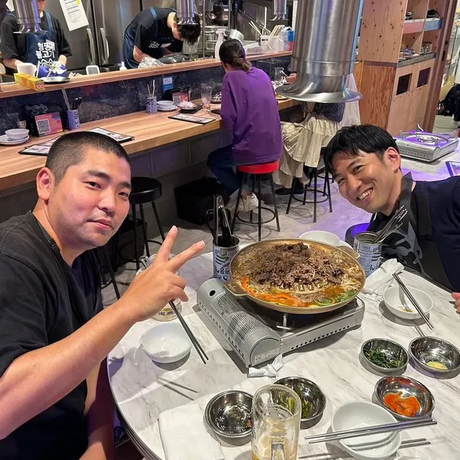 食事会のテーブルを囲んで談笑している職員。